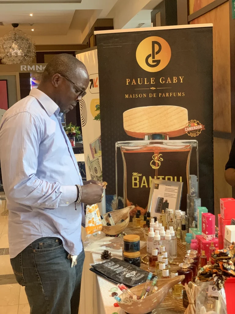 Visiteur découvrant les parfums Paule Gaby devant le kakémono Bantou au MARKRYS
