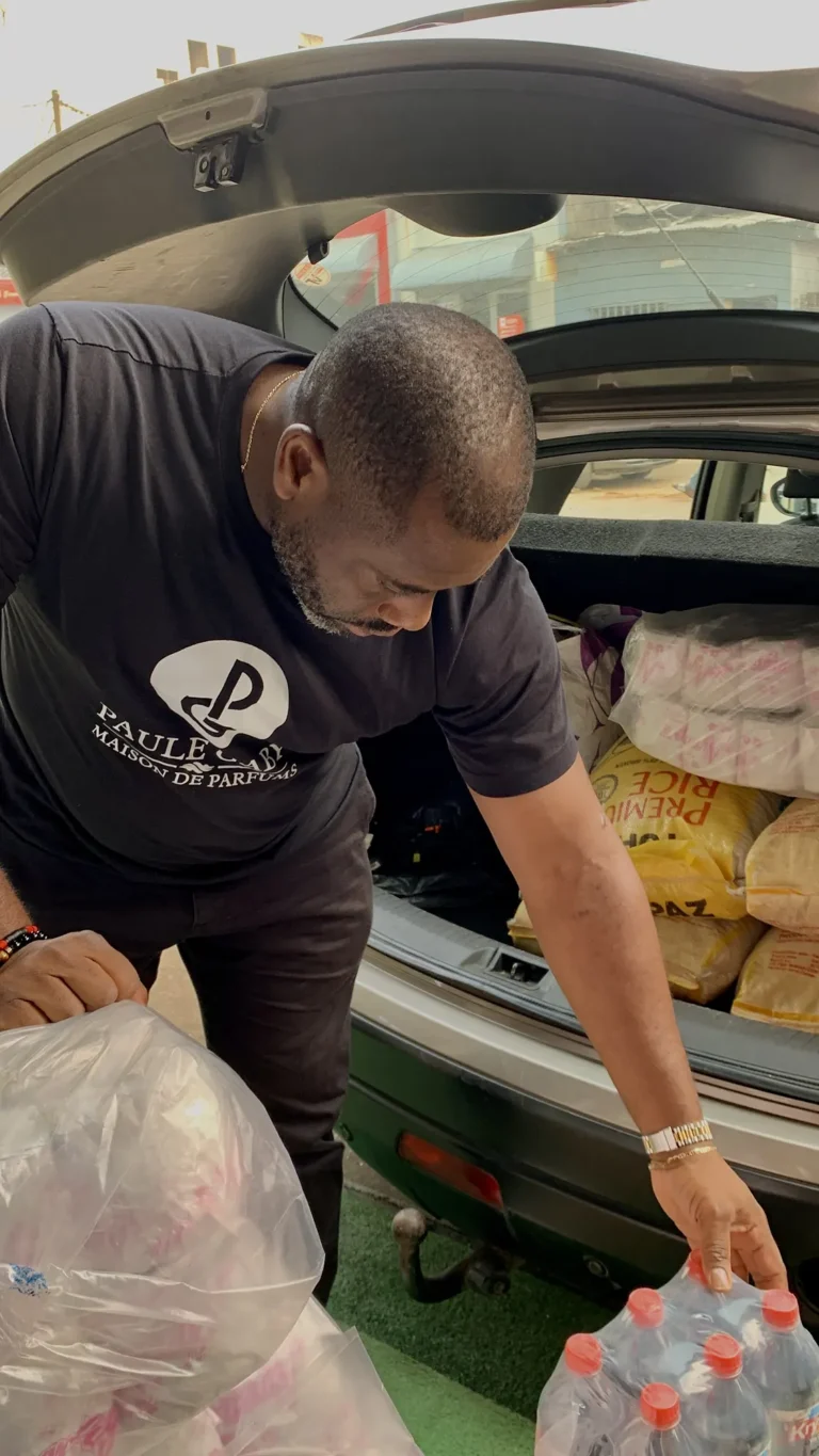 Membre de l'équipe Paule Gaby déchargeant des dons pour un orphelinat de New-Bell, à Douala, en décembre 2025
