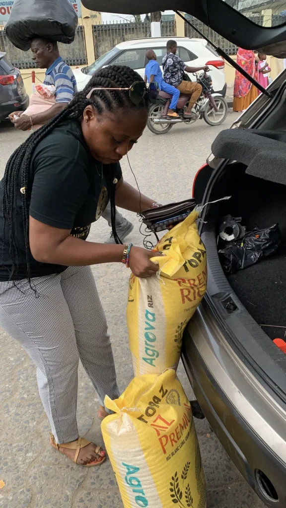 Bénévole Paule Gaby portant des sacs de riz destinés à l'orphelinat